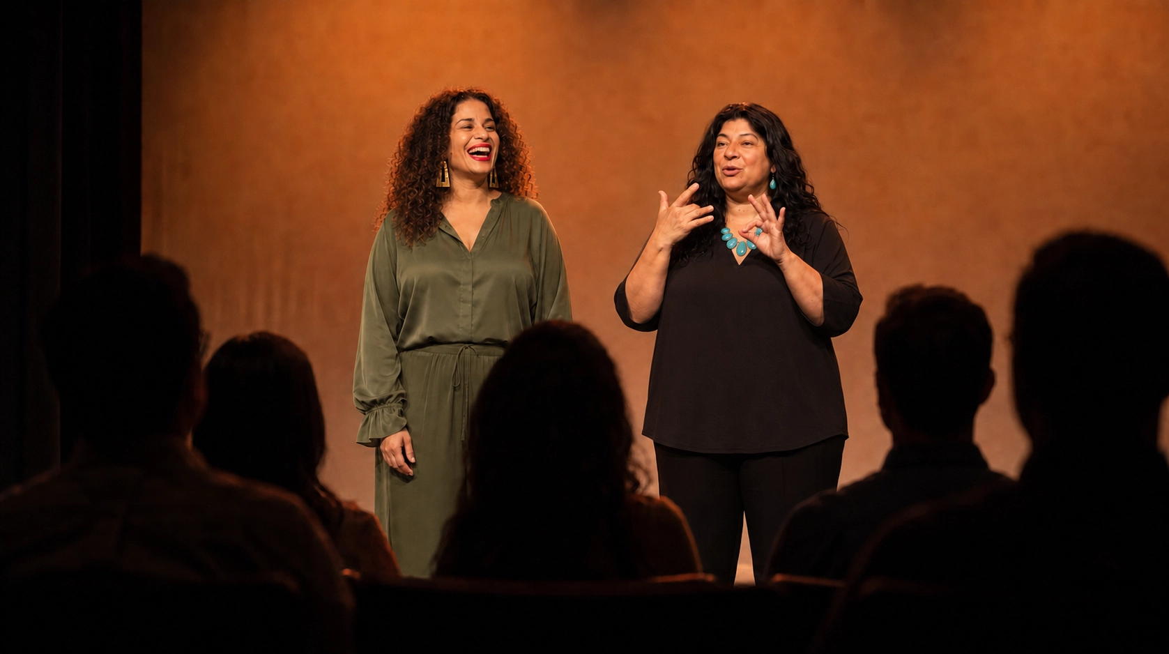 Two women on stage presenting to an audience